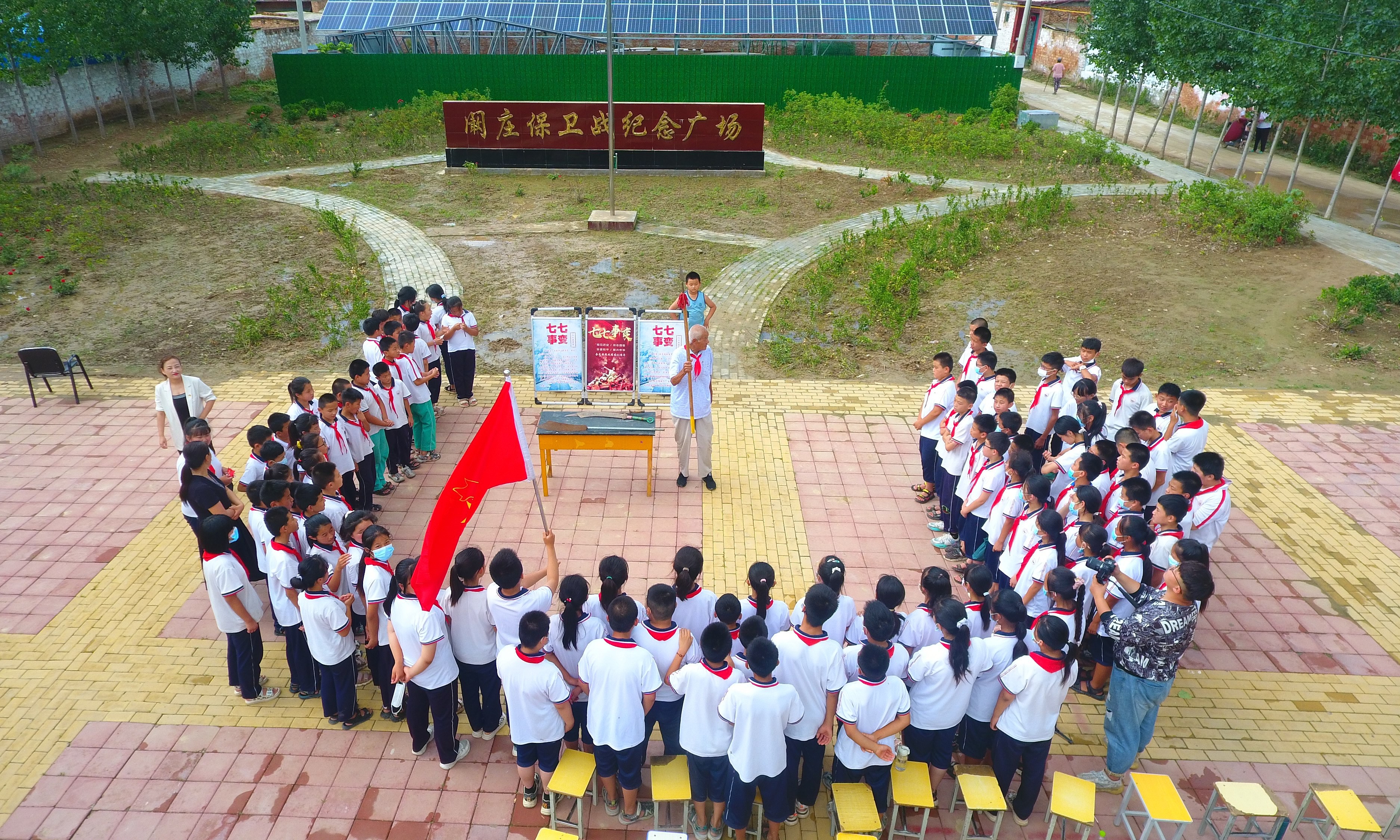 2022年7月6日，山東省聊城市，在茌平區(qū)菜屯鎮(zhèn)闞莊村的闞莊保衛(wèi)戰(zhàn)紀(jì)念廣場，闞莊保衛(wèi)戰(zhàn)親歷者王光木老人，為小學(xué)生們講述抗戰(zhàn)故事，展示大刀、長矛。